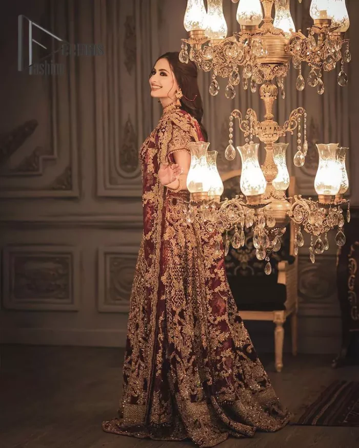 With the right outfit, every bride can rule the world! As nothing makes a bride more beautiful than the trust of her outfit. Introducing maroon half sleeves blouse that is fully embellished with tilla, kora and dabka work. In addition to this, the boat shape neckline of this blouse that is made with pure velvet gives you a dreamy look. It is synchronized with a velvet lehenga that is adorned with priceless heavy embroidery. Finish this look with an organza dupatta, embellished with embroidered scalloped borders to give you a relaxing and soothing look on your reception.