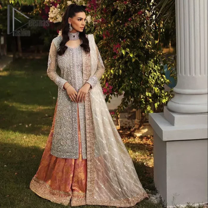 It's time to stock up your eventry wardrobe with the ensembles that have everyone hooked. Your mini fashionistas got stunned in this mint green and rust attire. Just look at the super detailing of a mint green front open shirt that is ornamented with silver embroidery that includes tilla, kora dabka, and crystal work. It is further enhanced with a Round neckline that gives so soothing display. It is coordinated with a Rust sharara, the border is sprinkled with silver embroidery and sequins spray all over that looks just priceless at any party. End up this attire with an ivory dupatta with a four-sided embellished border.