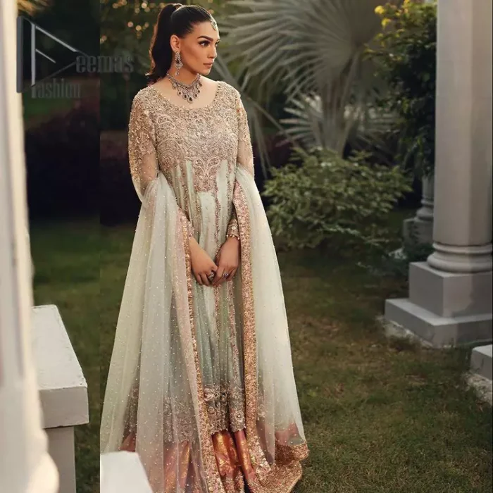 Unveiling your inner happiness is what it's all about your outfit. Just seep royalty in the texture and layers of this mint green scalloped maxi of DeemasFashion. The round neckline of the maxi is looking super aesthetic when comes with full sleeves. Further, the maxi is beautifully adorned with golden and antique embroidery that includes mainly tilla, gota, and crystal work just to give you a soothing and amazing look. Marvellously maxi is paired up with rust sharara with embroidered border to express your happiness as well. Finish this look with a mint green dupatta that is highlighted with a rust border and sequins spray all over it that seeps the royalty of the article.