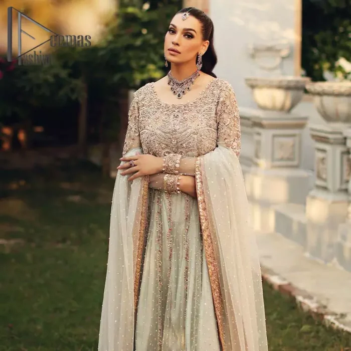 Unveiling your inner happiness is what it's all about your outfit. Just seep royalty in the texture and layers of this mint green scalloped maxi of DeemasFashion. The round neckline of the maxi is looking super aesthetic when comes with full sleeves. Further, the maxi is beautifully adorned with golden and antique embroidery that includes mainly tilla, gota, and crystal work just to give you a soothing and amazing look. Marvellously maxi is paired up with rust sharara with embroidered border to express your happiness as well. Finish this look with a mint green dupatta that is highlighted with a rust border and sequins spray all over it that seeps the royalty of the article.