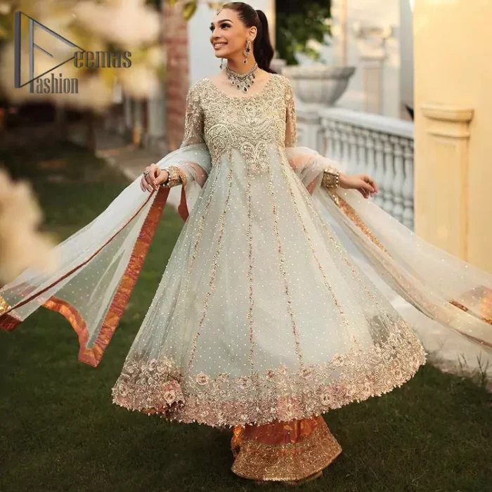 Unveiling your inner happiness is what it's all about your outfit. Just seep royalty in the texture and layers of this mint green scalloped maxi of DeemasFashion. The round neckline of the maxi is looking super aesthetic when comes with full sleeves. Further, the maxi is beautifully adorned with golden and antique embroidery that includes mainly tilla, gota, and crystal work just to give you a soothing and amazing look. Marvellously maxi is paired up with rust sharara with embroidered border to express your happiness as well. Finish this look with a mint green dupatta that is highlighted with a rust border and sequins spray all over it that seeps the royalty of the article.