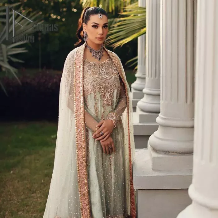Unveiling your inner happiness is what it's all about your outfit. Just seep royalty in the texture and layers of this mint green scalloped maxi of DeemasFashion. The round neckline of the maxi is looking super aesthetic when comes with full sleeves. Further, the maxi is beautifully adorned with golden and antique embroidery that includes mainly tilla, gota, and crystal work just to give you a soothing and amazing look. Marvellously maxi is paired up with rust sharara with embroidered border to express your happiness as well. Finish this look with a mint green dupatta that is highlighted with a rust border and sequins spray all over it that seeps the royalty of the article.