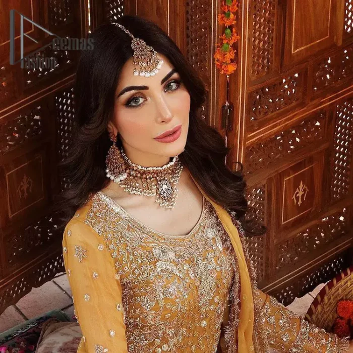 The shirt is the mirror of the mind and the dupatta confesses secrets of the heart. This mustard soft-toned article is highlighted with fascinating golden and antique kora, dabka, and crystal work. The shirt is further enhanced your mayon look with a traditional round neckline and full sleeves. It is paired up with gharara that is prettified with priceless border embroidery. Finish this look with the same colour dupatta that have four-sided embellished lace and Kiran. Further the sequins spray on the dupatta increases the beauty of the article which is every bride's dream.