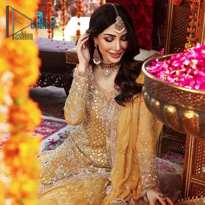The shirt is the mirror of the mind and the dupatta confesses secrets of the heart. This mustard soft-toned article is highlighted with fascinating golden and antique kora, dabka, and crystal work. The shirt is further enhanced your mayon look with a traditional round neckline and full sleeves. It is paired up with gharara that is prettified with priceless border embroidery. Finish this look with the same colour dupatta that have four-sided embellished lace and Kiran. Further the sequins spray on the dupatta increases the beauty of the article which is every bride's dream.