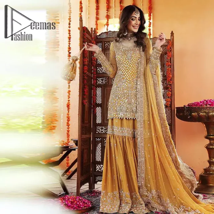 The shirt is the mirror of the mind and the dupatta confesses secrets of the heart. This mustard soft-toned article is highlighted with fascinating golden and antique kora, dabka, and crystal work. The shirt is further enhanced your mayon look with a traditional round neckline and full sleeves. It is paired up with gharara that is prettified with priceless border embroidery. Finish this look with the same colour dupatta that have four-sided embellished lace and Kiran. Further the sequins spray on the dupatta increases the beauty of the article which is every bride's dream.