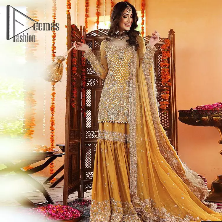 The shirt is the mirror of the mind and the dupatta confesses secrets of the heart. This mustard soft-toned article is highlighted with fascinating golden and antique kora, dabka, and crystal work. The shirt is further enhanced your mayon look with a traditional round neckline and full sleeves. It is paired up with gharara that is prettified with priceless border embroidery. Finish this look with the same colour dupatta that have four-sided embellished lace and Kiran. Further the sequins spray on the dupatta increases the beauty of the article which is every bride's dream.