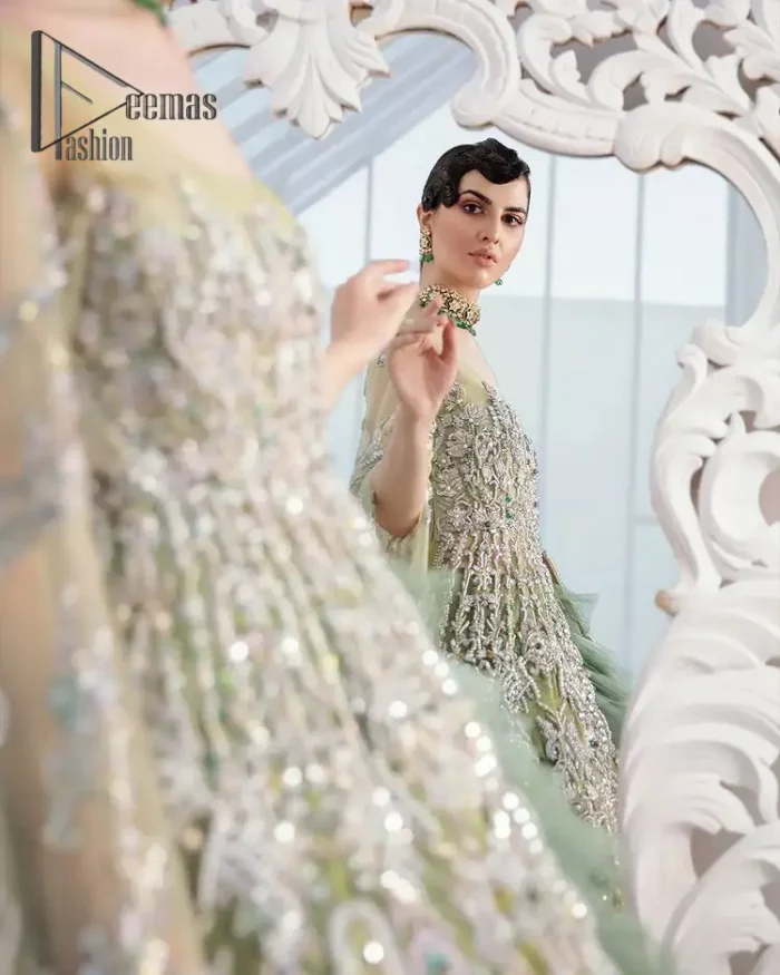 Confected on a luxury outfit with spectacular colors and contrast, this style serves for an elevated look. Delicate embroidery of maxi that involves kora, dabka, crystal work and front open style of maxi are infused together for the olive green affair. The very unbelievable sleeve style of the maxi looks super stunning and jazz up your event wardrobe. It is gracefully synchronized with a full frilled lehenga to enhance the beauty of the article. Complete this stunning look with an olive green scalloped dupatta that is embellished with four-sided borders and small motifs all around that reflect the mood of everyone.