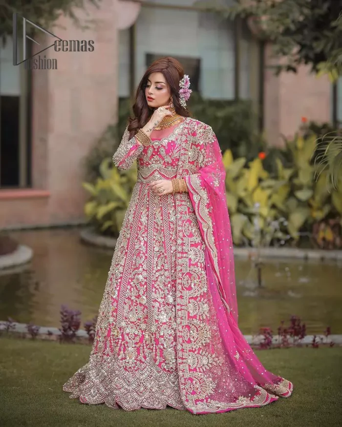 A colour splash, a floral dream. Let your energy shine with this pink outfit. Make a dramatic entry with pink scalloped pishwas that's full sleeves look super-duper amazing when combine with boat shape neckline. It is streaking with the finest silver and light golden embroidery that counts in tilla, kora, dabka, and crystal work to give you an enthusiast look. Further, this scalloped pishwas is coordinated with a Pink dupatta that is adorned with four-sided borders and sequins spray all over to give you shiny energy at any party.