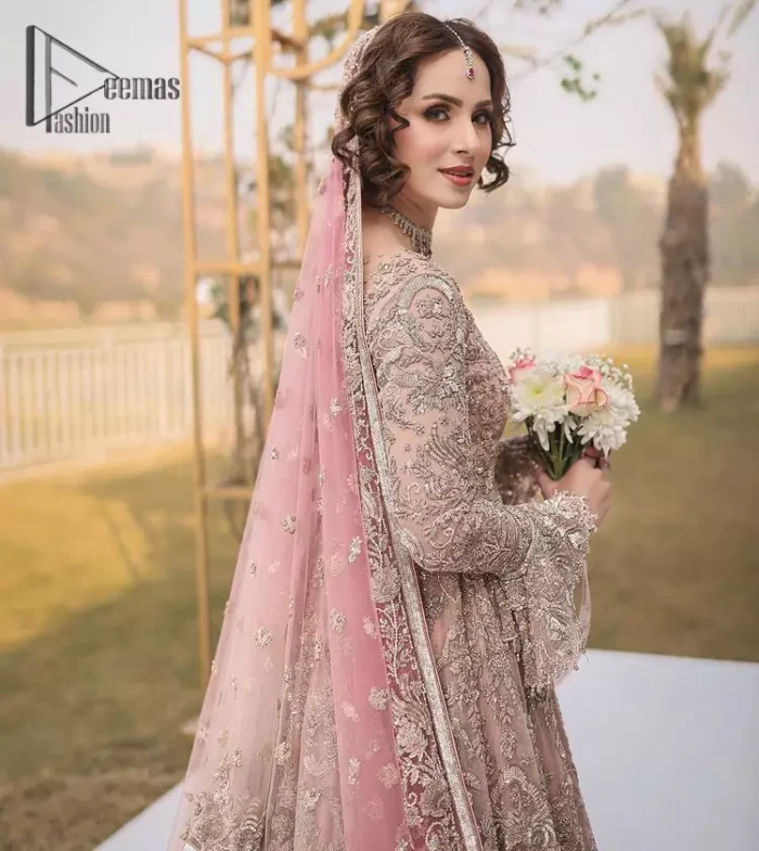 There is nothing more magical than wearing pink colour on your Walima. Our pink side slit open maxi is handsomely embellished with the magic of silver embroidery that involves kora, antiques, dabka, sequins, and pearls just to give you a dream fairy look. Further, the back train of the maxi is granted you the super dazzling effect. It is beautifully organized with a pink dupatta that is embellished with four-sided borders. Further, the dupatta is highlighted with the spray of tiny floral motifs all over just to enhance the fairy look.