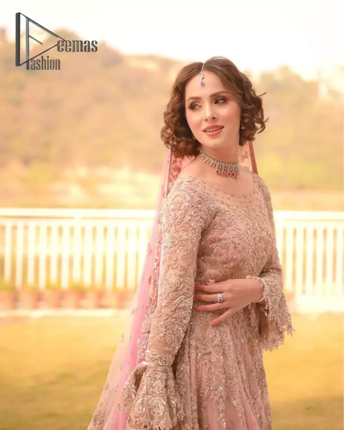 There is nothing more magical than wearing pink colour on your Walima. Our pink side slit open maxi is handsomely embellished with the magic of silver embroidery that involves kora, antiques, dabka, sequins, and pearls just to give you a dream fairy look. Further, the back train of the maxi is granted you the super dazzling effect. It is beautifully organized with a pink dupatta that is embellished with four-sided borders. Further, the dupatta is highlighted with the spray of tiny floral motifs all over just to enhance the fairy look.