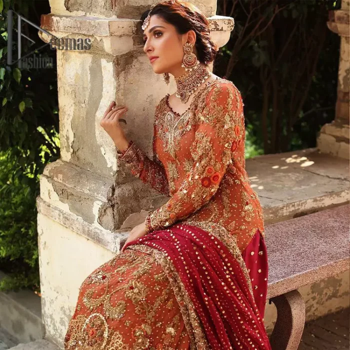 Wondering what an aesthetic bridal attire looks like? The beauty in red makes you go gaga over your look and you cannot stop snowing over you. Wearing the rust long shirt on your big day that is marvellously adorned with kora, dabka, and sequins work. Furthermore, the round neckline is also beautifully decorated to enhance the beauty of the outfit. It is synchronized with a red lehenga that has sequins sprayed all over to give you a crazy look as well. Finish this look with a red dupatta that has four-sided embellished borders as well.