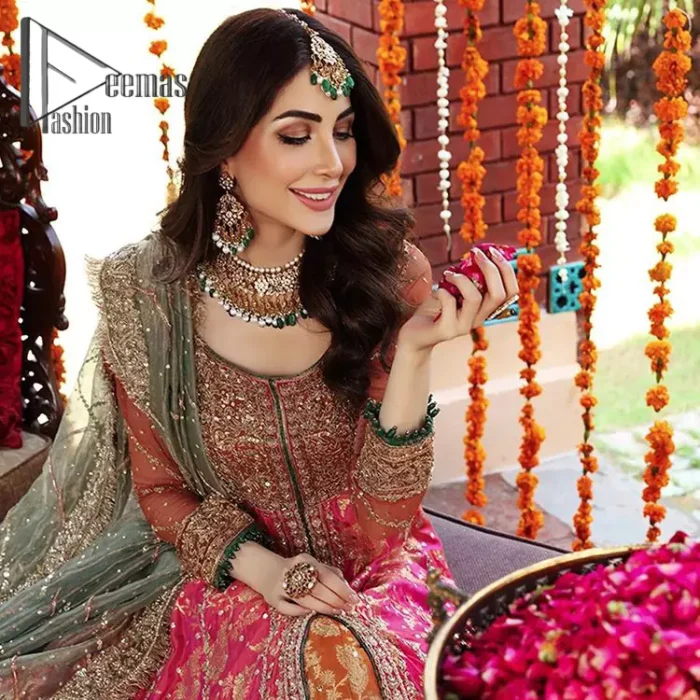 Be one with defying fashion winds and become a trendsetter. The captivating combination of front open style with the round neckline of shocking pink pishwas gives a stunning and smart look to you at any event. Pishwas is further furnished with attractive and handsome golden embroidery that includes mainly kora, dabka, and tilla work. Balance it with Rush Lehanga that have embellished with heavy border and sequins spray all-around to give soothing look. Complete this eventry look with a mint green dupatta that has been embellished with four-sided lace to give you a trendsetter look.