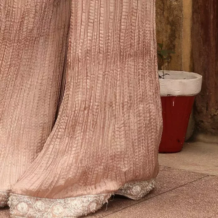 Nothing spells magic quite like a tea rose outfit on your big day. An engrossing shirt and crushed sharara style provide unparalleled majesty and impressiveness to the overall dress code all made with the purest of the tissue. This tea rose full sleeve shirt is heavily embellished with silver embroidery that includes pearls, kora and dabka work. Our attire and the way we put ourselves together sometimes speaks louder than our words. So, we set it up with tea rose crushed sharara to balance the magical fairytale look.