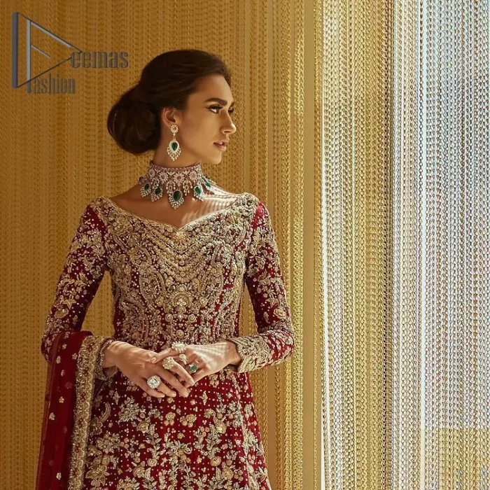 Serving a bold and funky style affair perfect for the big day. Stun in this classic base with contemporary golden adornment serving an elevated style. Detailing of the deep red frock is starting from the delightful and charming golden embroidery which is highlighted with tilla, zardozi, dabka and pearls. The V shape neckline of the frock is as lovely as you can see in the picture. Further, the bottom of the frock is enhanced with the scalloped border as well. It is arranged with the same colour lehenga that is also ornamented with heavy golden embroidery. Finally, end up this outfit with a deep red dupatta which is embellished with a four-sided border and sequins spray all over.