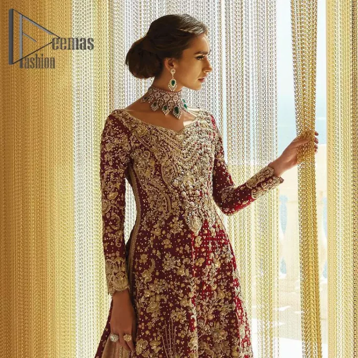Serving a bold and funky style affair perfect for the big day. Stun in this classic base with contemporary golden adornment serving an elevated style. Detailing of the deep red frock is starting from the delightful and charming golden embroidery which is highlighted with tilla, zardozi, dabka and pearls. The V shape neckline of the frock is as lovely as you can see in the picture. Further, the bottom of the frock is enhanced with the scalloped border as well. It is arranged with the same colour lehenga that is also ornamented with heavy golden embroidery. Finally, end up this outfit with a deep red dupatta which is embellished with a four-sided border and sequins spray all over.