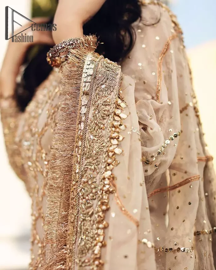 Opt for a versatile outfit for your Nikkah that is the perfect amalgamation of splendid colours, deluxe fabrication, and exquisite profile as well. Satiate your soul with extraordinary ensembles from this fawn short shirt gharara of DeemasFashion outfits. The round neckline of the short shirt is just amazing when combine with full sleeves. Further, it is highlighted with antique embroidery that includes tilla, kora, and dabka work. Pair up it with fawn gharara made with pure Katan banarsi jamawar fabric just to grant you a super aesthetic look. Complete this outfit with a fawn dupatta that is embellished with a four-sided embellished border and kiran lace as well.