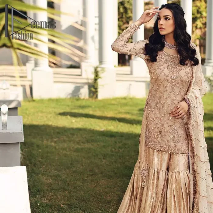 Opt for a versatile outfit for your Nikkah that is the perfect amalgamation of splendid colours, deluxe fabrication, and exquisite profile as well. Satiate your soul with extraordinary ensembles from this fawn short shirt gharara of DeemasFashion outfits. The round neckline of the short shirt is just amazing when combine with full sleeves. Further, it is highlighted with antique embroidery that includes tilla, kora, and dabka work. Pair up it with fawn gharara made with pure Katan banarsi jamawar fabric just to grant you a super aesthetic look. Complete this outfit with a fawn dupatta that is embellished with a four-sided embellished border and kiran lace as well.