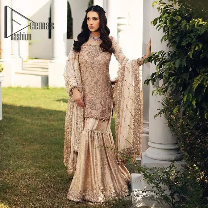 Opt for a versatile outfit for your Nikkah that is the perfect amalgamation of splendid colours, deluxe fabrication, and exquisite profile as well. Satiate your soul with extraordinary ensembles from this fawn short shirt gharara of DeemasFashion outfits. The round neckline of the short shirt is just amazing when combine with full sleeves. Further, it is highlighted with antique embroidery that includes tilla, kora, and dabka work. Pair up it with fawn gharara made with pure Katan banarsi jamawar fabric just to grant you a super aesthetic look. Complete this outfit with a fawn dupatta that is embellished with a four-sided embellished border and kiran lace as well.