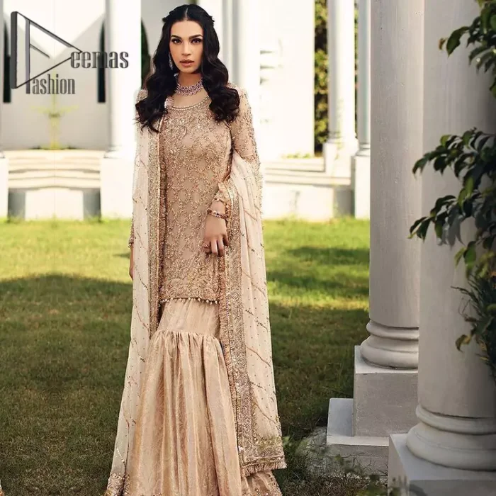 Opt for a versatile outfit for your Nikkah that is the perfect amalgamation of splendid colours, deluxe fabrication, and exquisite profile as well. Satiate your soul with extraordinary ensembles from this fawn short shirt gharara of DeemasFashion outfits. The round neckline of the short shirt is just amazing when combine with full sleeves. Further, it is highlighted with antique embroidery that includes tilla, kora, and dabka work. Pair up it with fawn gharara made with pure Katan banarsi jamawar fabric just to grant you a super aesthetic look. Complete this outfit with a fawn dupatta that is embellished with a four-sided embellished border and kiran lace as well.