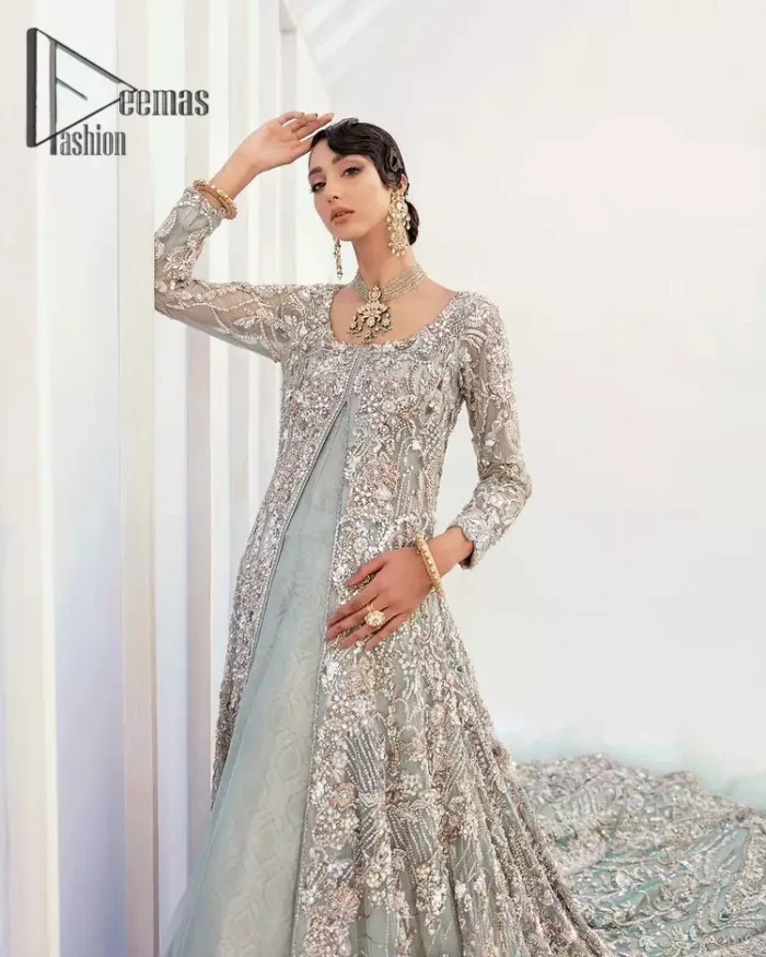 Sync. Style. Slay! A wedding is better when you get a super stylish all-in-one. DeemasFashion presents you with an ice-blue front open maxi this is decorated with silver embroidery which involves tilla, dabka, kora, and pearls work to magnify your inner pleasure on your Walima day. It is dominant with full sleeves just to grant you an aesthetic look. It is attractively coordinated with an ice blue lehenga with back train styling to give you a fairy look. Complete this outfit with the same colour dupatta that is beautifully embellished with floral motifs and a four-sided border.