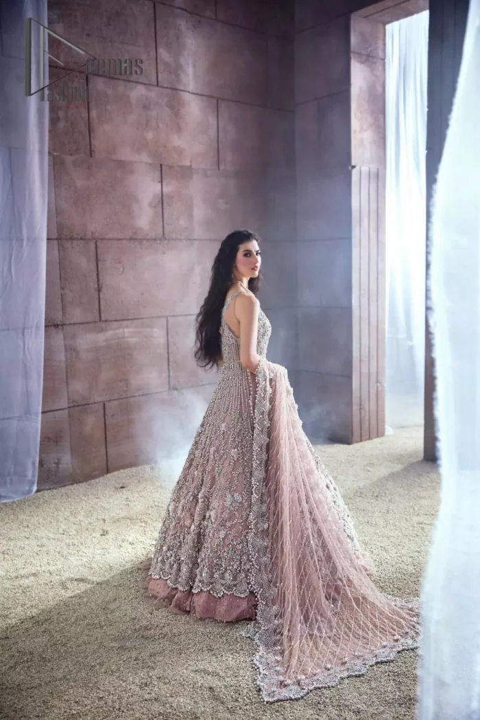 Rose, glitter, and glam are the mood. Shine through with all eyes on you! A full festive package dipped in an oyster pink tone. Presenting oyster pink front open maxi for your Walima day just to boost up your inner happiness. The maxi is handsomely adorned with silver embroidery that is embellished with tilla, kora, dabka, and pearls work. Furthermore, it is highlighted with full sleeves just to give you glam and shiny look. It is systemized with an oyster pink lehenga to give you a superstar look. End up this article with the same colour dupatta that is prominent with a four-sided embellished border and sequins spray all over.