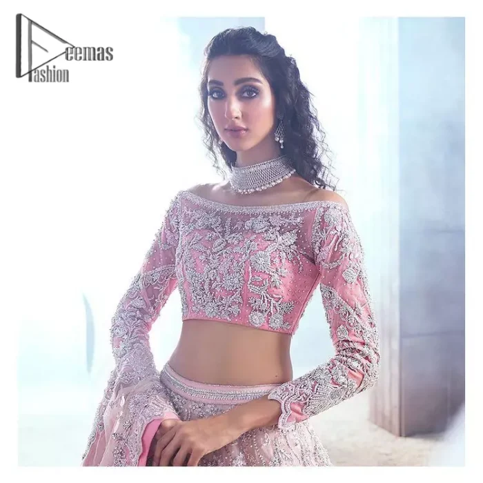 DeemasFashion just defines sophistication and minimal high fashion in terms you desire. Reveal your aura in this tea pink off-shoulder blouse that is beautifully decorated with silver embroidery that involves a kora, dabka, tilla, and crystal look just to grant you mesmerizing look. Further, the full sleeves of the blouse look so admiring on your walima day. It is arranged with a frilled lehenga again which is ornamented with heavy silver embroidery so that you can steal everyone's heart. Finish this article with a tea pink dupatta that is prominent with four-sided border embellishment.