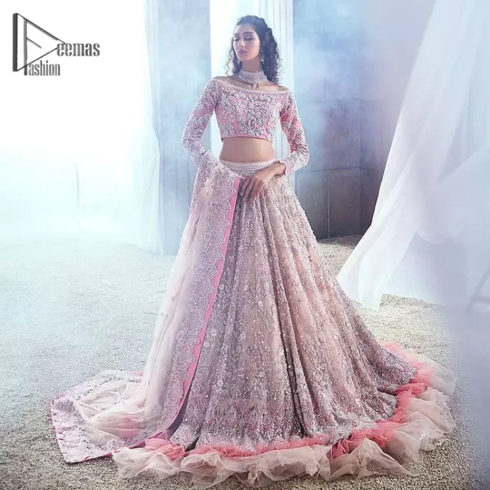 Deemas Fashion just defines sophistication and minimal high fashion in terms you desire. Reveal your aura in this tea pink off-shoulder blouse that is beautifully decorated with silver embroidery that involves a kora, dabka, tilla, and crystal look just to grant you mesmerizing look. Further, the full sleeves of the blouse look so admiring on your walima day. It is arranged with a frilled lehenga again which is ornamented with heavy silver embroidery so that you can steal everyone's heart. Finish this article with a tea pink dupatta that is prominent with four-sided border embellishment.