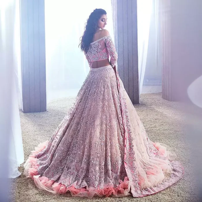 DeemasFashion just defines sophistication and minimal high fashion in terms you desire. Reveal your aura in this tea pink off-shoulder blouse that is beautifully decorated with silver embroidery that involves a kora, dabka, tilla, and crystal look just to grant you mesmerizing look. Further, the full sleeves of the blouse look so admiring on your walima day. It is arranged with a frilled lehenga again which is ornamented with heavy silver embroidery so that you can steal everyone's heart. Finish this article with a tea pink dupatta that is prominent with four-sided border embellishment.