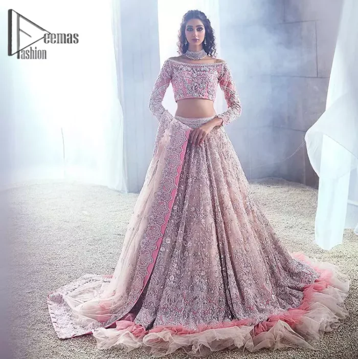 DeemasFashion just defines sophistication and minimal high fashion in terms you desire. Reveal your aura in this tea pink off-shoulder blouse that is beautifully decorated with silver embroidery that involves a kora, dabka, tilla, and crystal look just to grant you mesmerizing look. Further, the full sleeves of the blouse look so admiring on your walima day. It is arranged with a frilled lehenga again which is ornamented with heavy silver embroidery so that you can steal everyone's heart. Finish this article with a tea pink dupatta that is prominent with four-sided border embellishment.