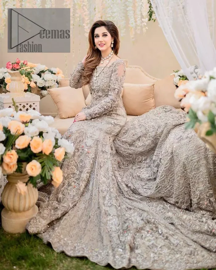 Embrace happiness on your Walima in the colour of beige-pink along this dreamiest fairy tail maxi. The floral fusion of tilla and thread embroidery on a royal beige-pink maxi is to fulfil your dreamy look. The boat shape neckline of this maxi is as amazing as the whole maxi. Further, it is fully embellished with tilla, kora, dabka and sequins work just to enhance the beauty of your Walima day. The fairy tale is also adorned with heavy work and looks super amazing when combine with full sleeves style. Finish this fairy look with the same colour dupatta that is ornamented with a four-sided border and sequins sprayed all over to increase the look of this article.