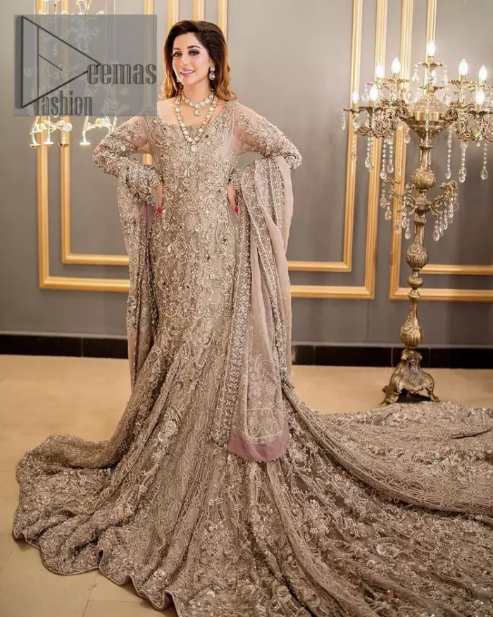 Embrace happiness on your Walima in the colour of beige-pink along this dreamiest fairy tail maxi. The floral fusion of tilla and thread embroidery on a royal beige-pink maxi is to fulfil your dreamy look. The boat shape neckline of this maxi is as amazing as the whole maxi. Further, it is fully embellished with tilla, kora, dabka and sequins work just to enhance the beauty of your Walima day. The fairy tale is also adorned with heavy work and looks super amazing when combine with full sleeves style. Finish this fairy look with the same colour dupatta that is ornamented with a four-sided border and sequins sprayed all over to increase the look of this article.
