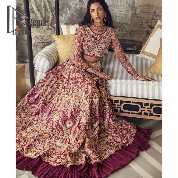Create your own uniqueness. Let it be priceless for yourself and yet identifiable for others. Introducing burgundy blouse which is heavily adorned with golden embroidery that includes kora, doabka and magic of tilla. It is enhanced with the round shape neckline and full sleeves to make your remarkable moments lovely and a little romantic. Furthermore, it is systemized with a frilled lehenga that is again embellished with heavy embroidery. Finish this outfit with a scalloped dupatta in the same colour that is ornamented with a four-sided border to make you the priceless bride. 