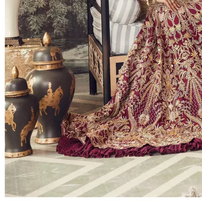 Create your own uniqueness. Let it be priceless for yourself and yet identifiable for others. Introducing burgundy blouse which is heavily adorned with golden embroidery that includes kora, doabka and magic of tilla. It is enhanced with the round shape neckline and full sleeves to make your remarkable moments lovely and a little romantic. Furthermore, it is systemized with a frilled lehenga that is again embellished with heavy embroidery. Finish this outfit with a scalloped dupatta in the same colour that is ornamented with a four-sided border to make you the priceless bride. 