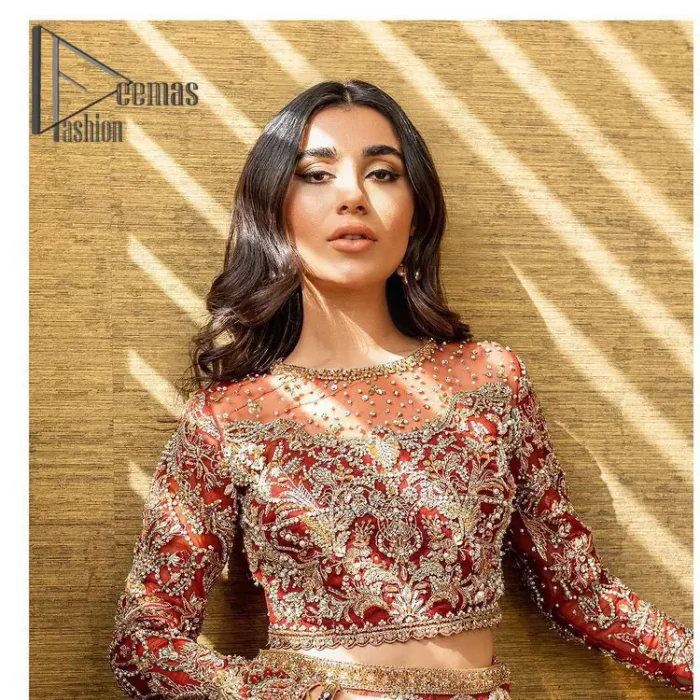 Create your own uniqueness. Let it be priceless for yourself and yet identifiable for others. Introducing burgundy blouse which is heavily adorned with golden embroidery that includes kora, doabka and magic of tilla. It is enhanced with the round shape neckline and full sleeves to make your remarkable moments lovely and a little romantic. Furthermore, it is systemized with a frilled lehenga that is again embellished with heavy embroidery. Finish this outfit with a scalloped dupatta in the same colour that is ornamented with a four-sided border to make you the priceless bride. 