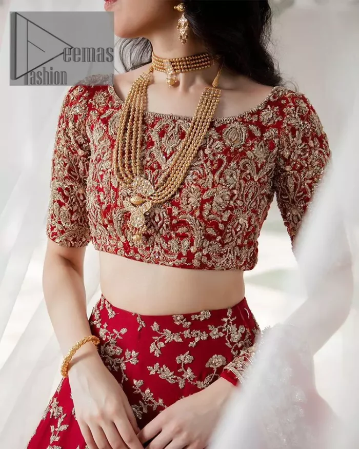 Envelop yourself into the dazzling love affair. Surprise everyone with this deep red article on your Big day. Stating this article with a deep red blouse that is handsomely styled with boat shape neckline. The half sleeves of the blouse just boost the attractiveness of the design.  In addition to this, it is delightfully furnished with golden embroidery which includes kora, dabka and tilla. Brace the blouse with a deep red fluffy lehenga that is again heavily embellished with golden embroidery that increases the beauty of the article. Complete this article with the same colour dupatta which is embellished with a four-sided borders and sequins sprayed all over just to envelop you into the dazzling love affair on your big day. 