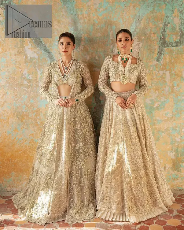 With a touch of Divine. A stunning ivory blouse is laboriously frosted with meticulously detailed hand embellishment with kora, dabka, tilla and pearls all over. The sweetheart neckline of the blouse and full sleeves together gives a so romantic look to any bride. In addition to this, it is systemized with the same colour frilled lehenga which is laden with the same colour embroidery that gives a magical stream of tilla, dabka and pearls. Finish this ivory article with the same colour dupatta that is heavily embellished with four-sided handsome borders and sequins sprayed all over to enhance the feeling of joy. 