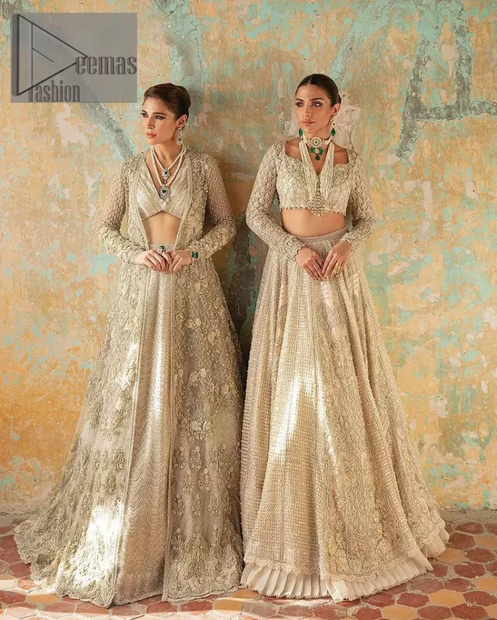 With a touch of Divine. A stunning ivory blouse is laboriously frosted with meticulously detailed hand embellishment with kora, dabka, tilla and pearls all over. The sweetheart neckline of the blouse and full sleeves together gives a so romantic look to any bride. In addition to this, it is systemized with the same colour frilled lehenga which is laden with the same colour embroidery that gives a magical stream of tilla, dabka and pearls. Finish this ivory article with the same colour dupatta that is heavily embellished with four-sided handsome borders and sequins sprayed all over to enhance the feeling of joy. 