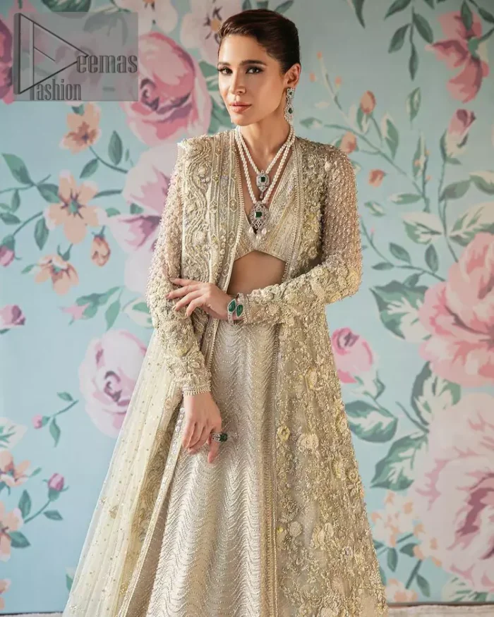 On a magical ivory afternoon, the sun reflects her radiance, the wind mimics her gaze. Starting this ivory article with an attractive and romantic blouse that is beautifully adorned with the same colour embroidery. The V shape neckline of the blouse adds a lovely feeling as well. In addition to this, it is organized with the same colour front open gown that is heavily adorned with tilla, dabka, kora and pearls embroidery. It is highlighted with full sleeves style that shows the uniqueness of the article. Paired up with the same colour lehenga to boost up the walima day of every bride. Complete this article with an ivory dupatta that is embellished with four-sided borders and sequins spray and tiny floral motifs spread all over. 
