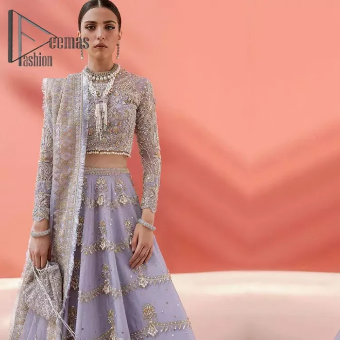 Love when our brides can completely be lost in the moment with their dresses. DeemasFashion presents a lilac article which is starting with a lilac blouse that is ornamented with golden embroidery. It is highlighted with tilla, dabka, pearls and the illusion of crystals. Furthermore, the full sleeves of the dress are attractively designed with a round shape neckline to boost your feelings on your walima day. It is handsomely coordinated with the same colour lehenga that is again embellished with golden embroidery. End up this outfit with the same colour dupatta that is embellished with four-sided borders and sequins sprayed all over to make a memorable event for the bride. 