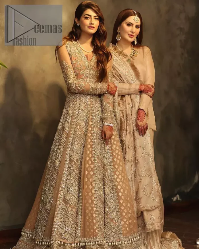 Its lustrous, lush and lavish in every sense of the word with its dazzling nude peach base. The nude peach multiple panel frock is amazing for your walima day. The V shape neckline is heavily embellished with embroidery. Further, this aesthetic nude peach frock is enhanced with silver pearls, tilla and dabka work. It is prominent with full sleeves that give a soothing effect to this article. It is complete in its pleasing loudness with an equal nude peach sharara that is adorned with silver embroidery just to fulfil the fairy dream of every bride. 