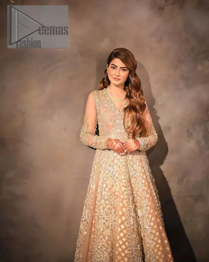 Its lustrous, lush and lavish in every sense of the word with its dazzling nude peach base. The nude peach multiple panel frock is amazing for your walima day. The V shape neckline is heavily embellished with embroidery. Further, this aesthetic nude peach frock is enhanced with silver pearls, tilla and dabka work. It is prominent with full sleeves that give a soothing effect to this article. It is complete in its pleasing loudness with an equal nude peach sharara that is adorned with silver embroidery just to fulfil the fairy dream of every bride. 