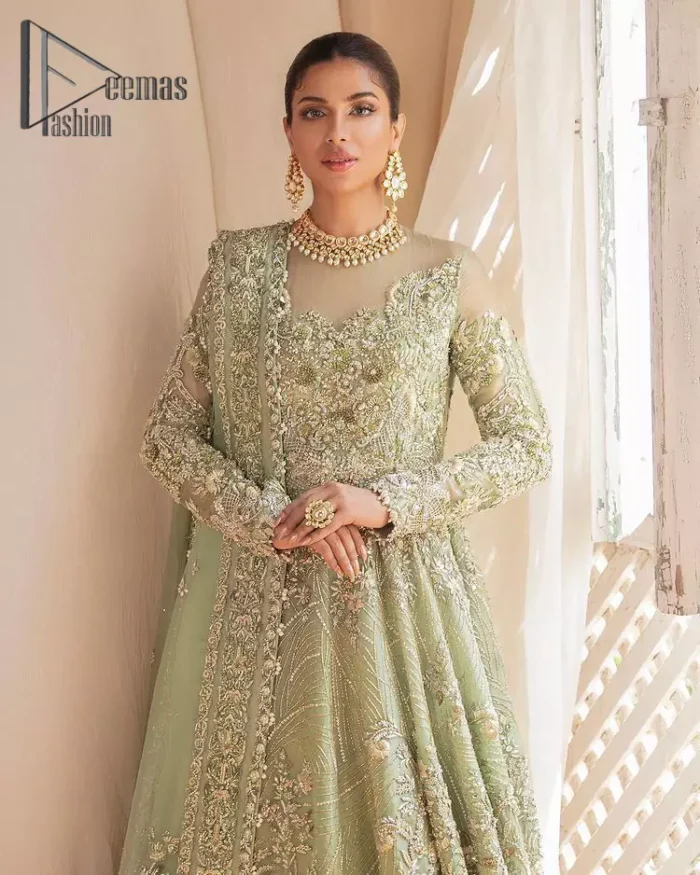 A time of life that is not just an occasion but a celebration. A pastel green scalloped maxi laboriously frosted with meticulously detailed hand embellished with silver tilla, dabka, and kora work blooming all over. Further, the jewel neckline and full sleeves of this article give so soothing feeling to you your walima day. It is handsomely coordinated with a pastel green lehenga that is again beautifully embellished. Complete this article with the organza dupatta in the same colour, heavily laden with a four-sided border and tiny floral motifs all over with a magical stream of pearls. 