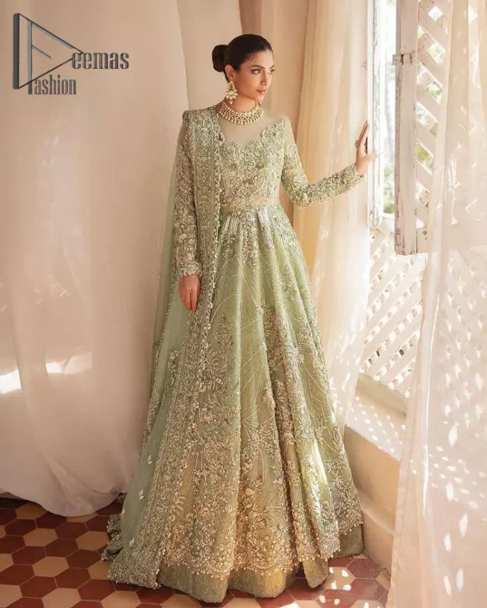 A time of life that is not just an occasion but a celebration. A pastel green scalloped maxi laboriously frosted with meticulously detailed hand embellished with silver tilla, dabka, and kora work blooming all over. Further, the jewel neckline and full sleeves of this article give so soothing feeling to you your walima day. It is handsomely coordinated with a pastel green lehenga that is again beautifully embellished. Complete this article with the organza dupatta in the same colour, heavily laden with a four-sided border and tiny floral motifs all over with a magical stream of pearls. 