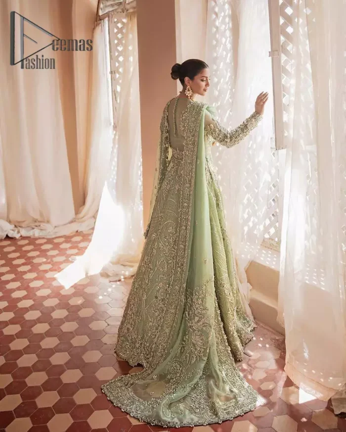 A time of life that is not just an occasion but a celebration. A pastel green scalloped maxi laboriously frosted with meticulously detailed hand embellished with silver tilla, dabka, and kora work blooming all over. Further, the jewel neckline and full sleeves of this article give so soothing feeling to you your walima day. It is handsomely coordinated with a pastel green lehenga that is again beautifully embellished. Complete this article with the organza dupatta in the same colour, heavily laden with a four-sided border and tiny floral motifs all over with a magical stream of pearls. 
