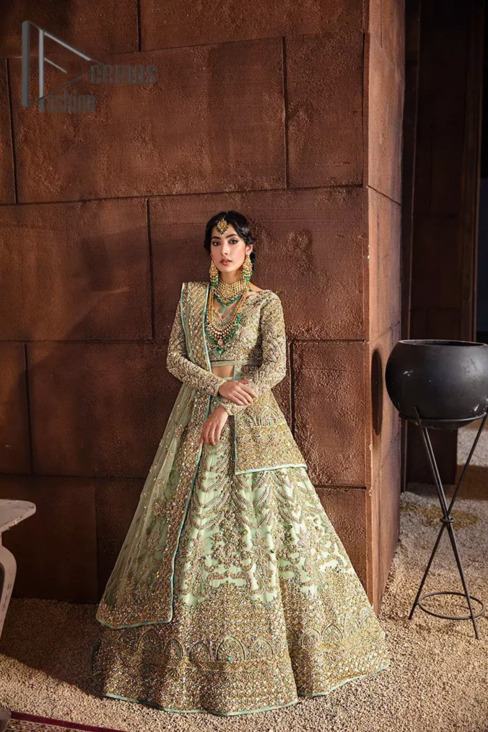 She was a dreamer, and so are we. A pistachio green front open short frock serves as a canvas for gold and pistachio green work with the magic of tilla, dabka, semi-precious stones and pearls. The V shape neckline is highlighted with full sleeves to add a galaxy in eyes of every bride. In addition to this, it is organized with the same colour fluffy lehenga which is again adorned with heavy golden embroidery to express the love of the bride on her walima day. Finish this outfit with the same colour dupatta which is embellished with four-sided borders and sequins sprayed all over.  