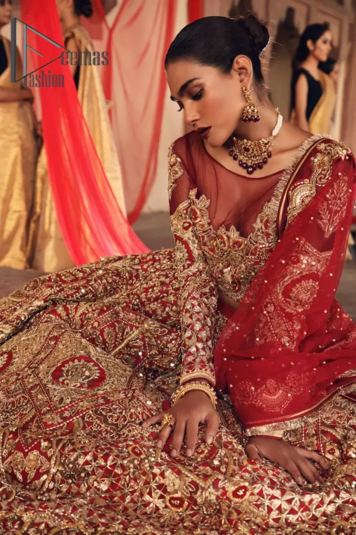Celebrate the most romantic moments of your Big Day in the style of DeemasFashion. The red blouse represents the love in the air with handsomely embellished golden embroidery which includes kora, dabka, tilla and zardozi. It is prominent with an illusion neck and combine with full sleeves to enhance the love of you for your lovely audience. It is coordinated with a lehenga which is heavily adorned with the finest embroidery and looks super splendid as well. Complete this lovely article with the same colour dupatta that is adorned with a four-sided border and sequins sprayed all over to give you the romantic look.