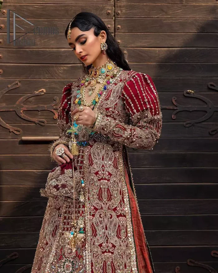 Look in my eyes, look how they shine for you and everything you do. DeemasFashion presents a very traditional outfit for the brides to wear the article on their Big Day. The traditional red long shirt is hand-rendered in silver and is enhanced with Resham, tilla, pearls, Sitara and naqshi. The V shape neckline and full sleeves added some magic and a dramatic look to the bride. Further, it is prominent with a blue heavy floral motif that is placed at the centre. The long shirt is organized with crushed share that truly defines the love and laughter of a bride. 