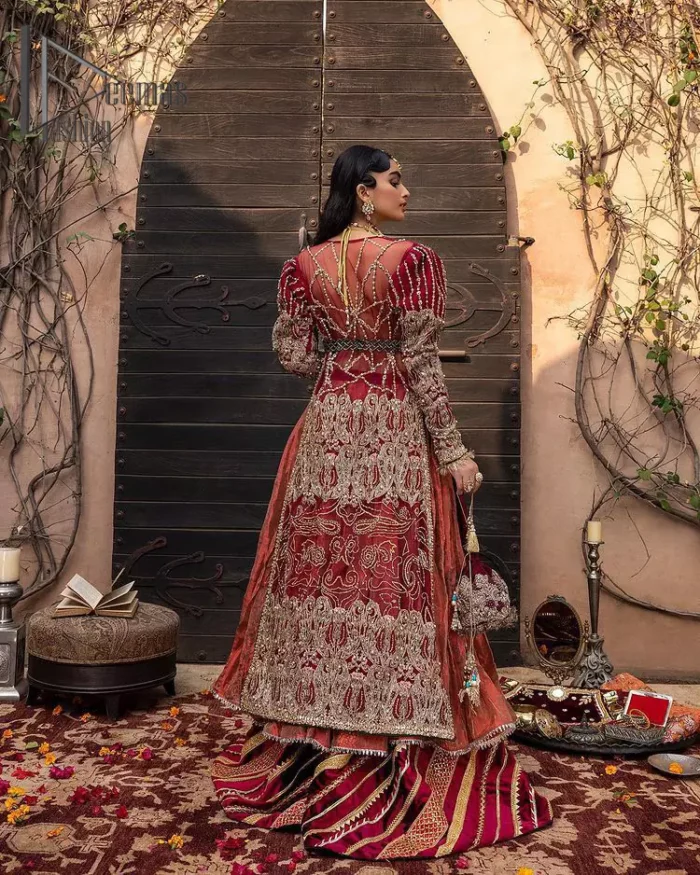 Look in my eyes, look how they shine for you and everything you do. DeemasFashion presents a very traditional outfit for the brides to wear the article on their Big Day. The traditional red long shirt is hand-rendered in silver and is enhanced with Resham, tilla, pearls, Sitara and naqshi. The V shape neckline and full sleeves added some magic and a dramatic look to the bride. Further, it is prominent with a blue heavy floral motif that is placed at the centre. The long shirt is organized with crushed share that truly defines the love and laughter of a bride. 