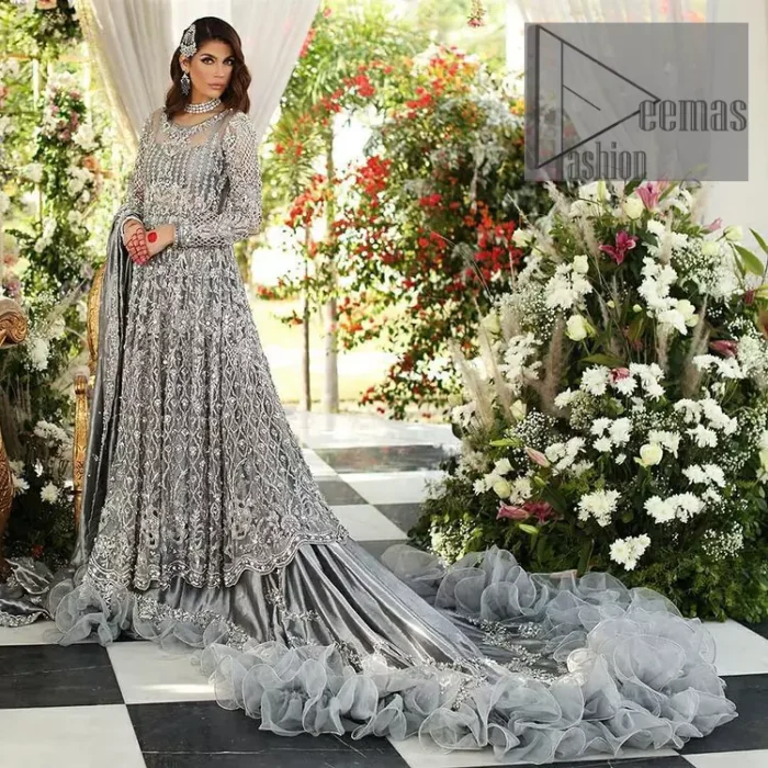 Walking into a new chapter of your life with the joy of togetherness and the magic of love. DeemasFashion presents a silver-grey maxi for your walima day that is handsomely adorned with a silver embroidery that comprises tilla, kora, dabka and crystal work. It is featured with a round neckline and full sleeves that grant you the feeling of joy. Parten this with back train shimmery lehenga which is beautifully organised with the same colour frill that enhances the overall charms of the unique article. Carry this article on your walima day and surprise your loved ones with this fairy look. 