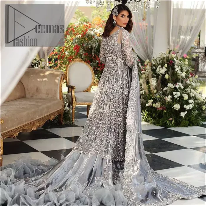 Walking into a new chapter of your life with the joy of togetherness and the magic of love. DeemasFashion presents a silver-grey maxi for your walima day that is handsomely adorned with a silver embroidery that comprises tilla, kora, dabka and crystal work. It is featured with a round neckline and full sleeves that grant you the feeling of joy. Parten this with back train shimmery lehenga which is beautifully organised with the same colour frill that enhances the overall charms of the unique article. Carry this article on your walima day and surprise your loved ones with this fairy look. 